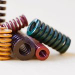 Abstract metal springs colorful steel spirals coil with different hardness flexibility sizes. gray background, soft focus shallow depth of field